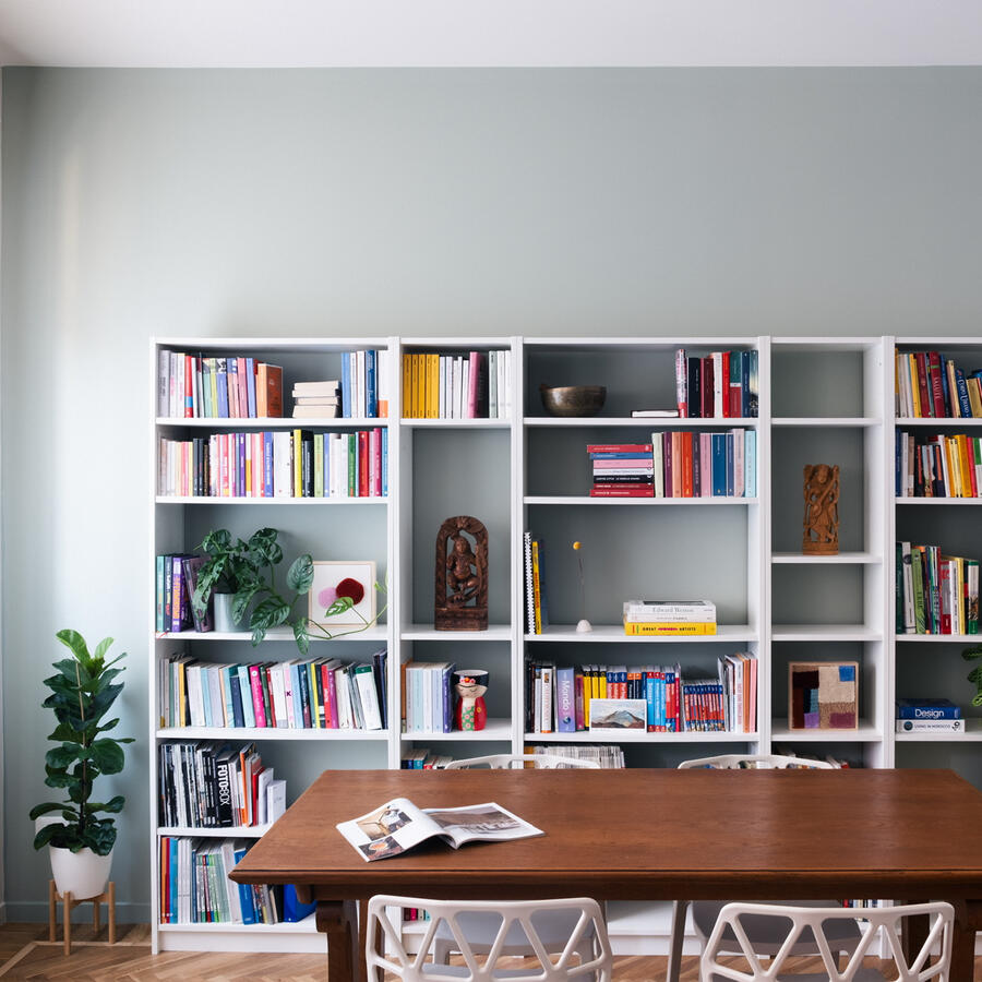 Libreria bianca e muro verde Sala da pranzo e libreria